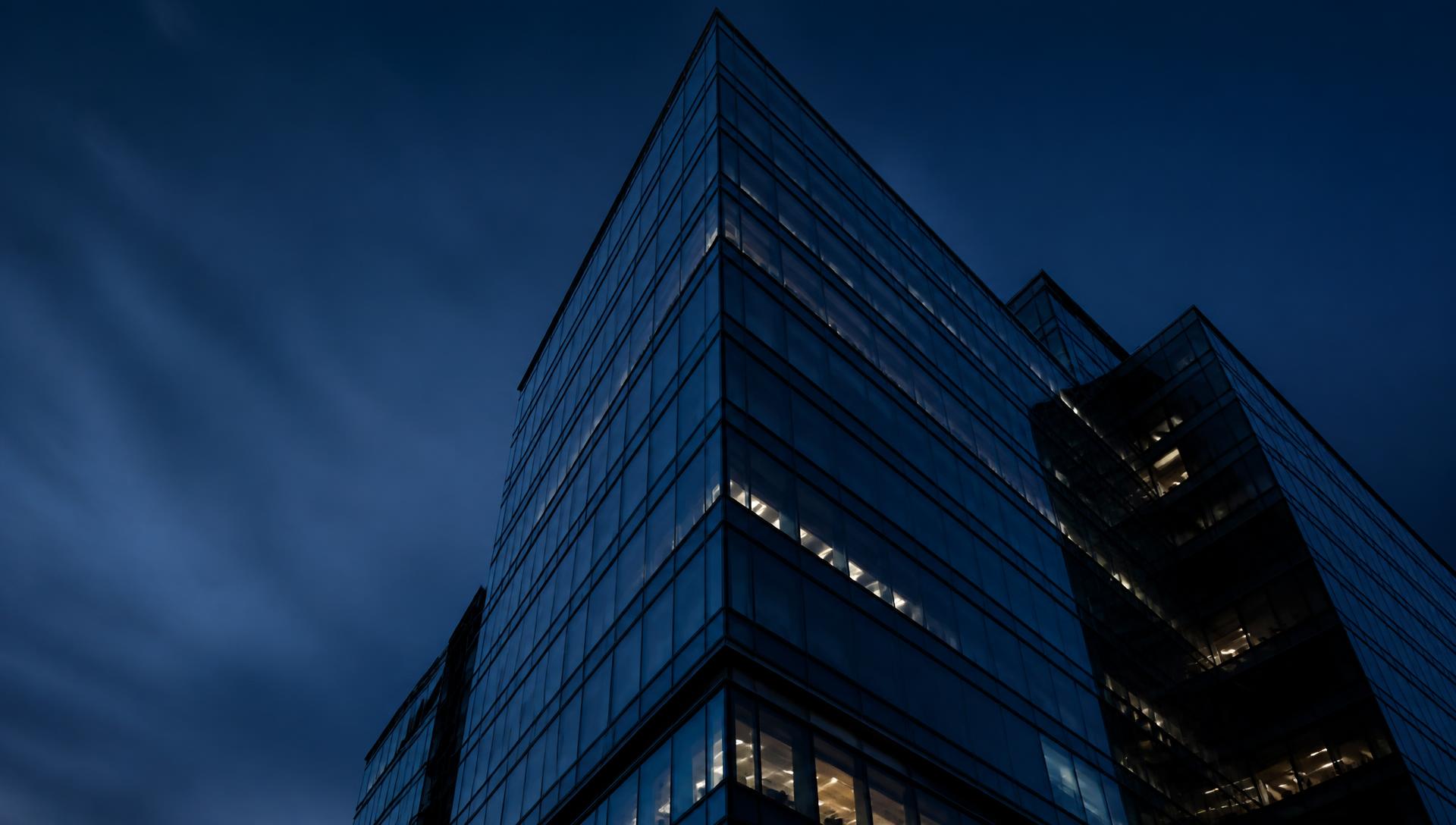 Modern glass office tower at dusk